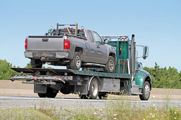 istock Tow Truck On Highway Transporting An Old Model, Unidentifiable Vehicle. 587774198