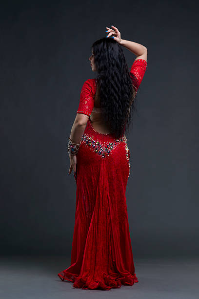 istock Women performs belly dance in red dress on gray background 587774710