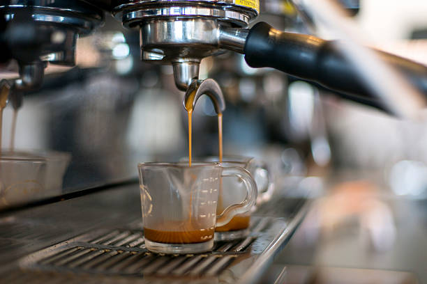 istock Double espresso spout dripping espresso into two shot glasses 587775640