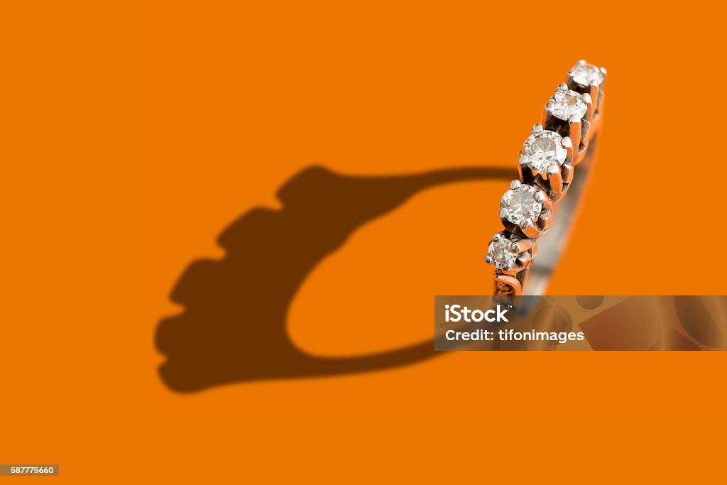 Diamond ring Diamond ring with shadow over an orange background Diamond - Gemstone Stock Photo