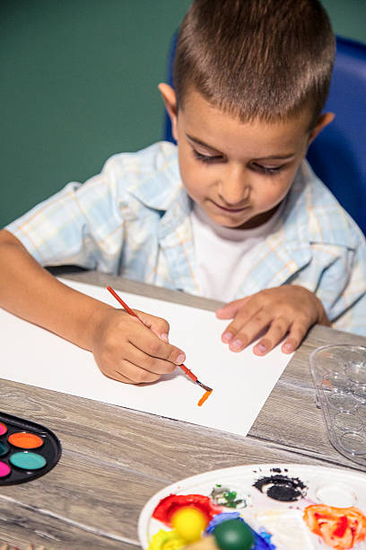 istock Small child painting with watercolors. 587776256