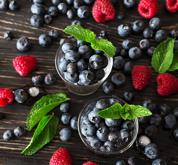 istock Blueberries, raspberries and mint at black wooden table. 587776258