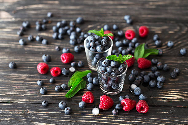 istock Blueberries, raspberries and mint at black wooden table. 587776324