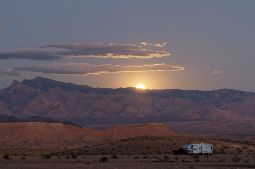 lone 5th-wheel in desert sunset on mesa