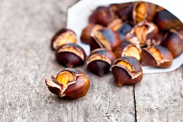 istock Roasted  chestnuts on wooden background 587778904