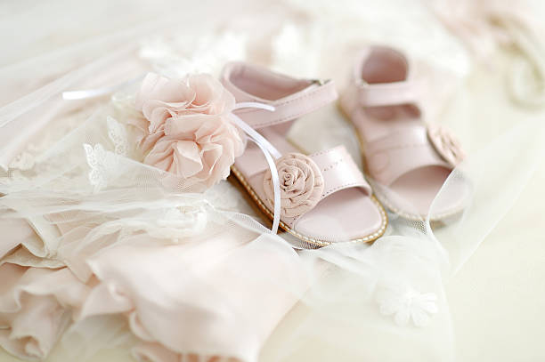 Baby girl christening shoes Baby girl christening shoes and flower headband baptism stock pictures, royalty-free photos & images