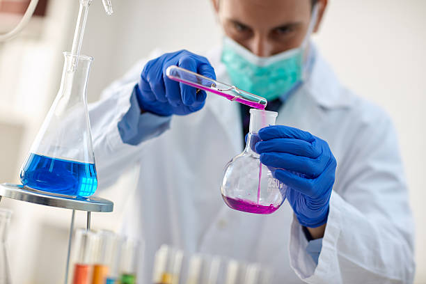 istock scientist with pipette and tubes making test 587780336
