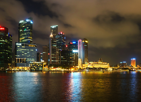 Singapore, Singapore - February 29, 2016: Singapore skyline of Downtown Core on Marina Bay at night. Cityscape of famous Skyscrapers illuminated with light and reflected in the water.