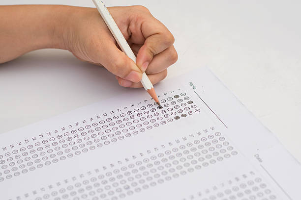 istock woman's hands filling in standardized test form 587780960