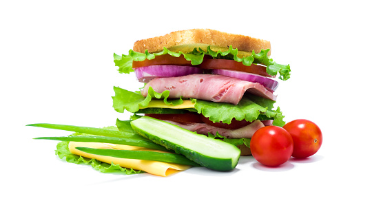 Double sandwich of bread, ham, cheese, tomato, cucumber, onion and lettuce and its ingredients isolated on white background.