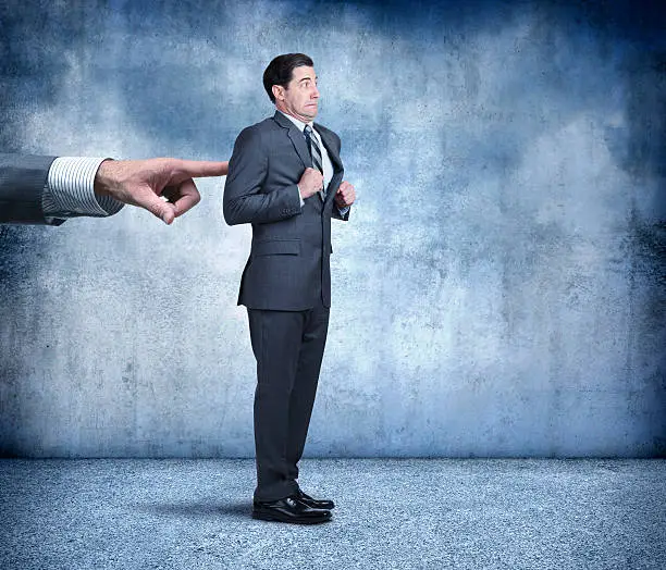 A reluctanct businessman resists the efforts of a large oversized hand that is trying to persuade him to move forward.