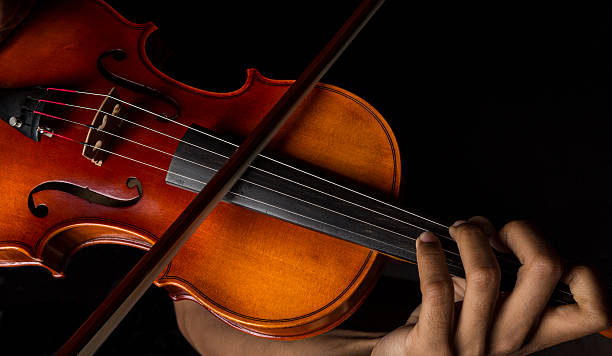 Man playing violin holding the bow African American Man playing violin holding the bow violin stock pictures, royalty-free photos & images