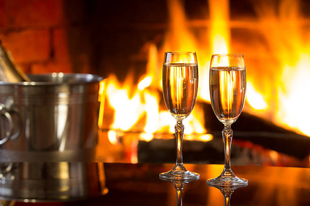 istock Sparkling wine in front of warm fireplace. Romantic, cozy atmosphere 587786092