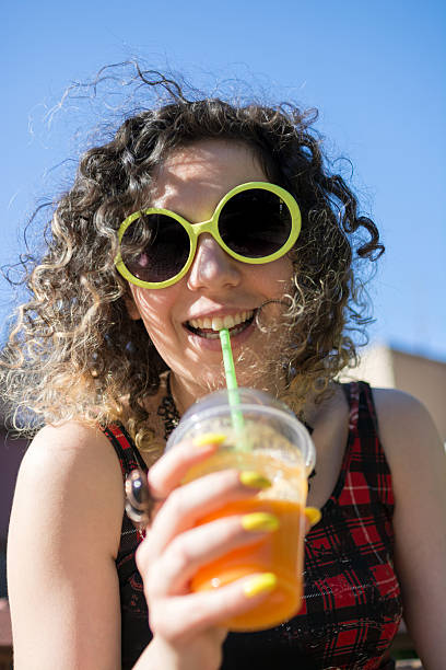 istock Young hipster woman drinking orange coctail 587786668