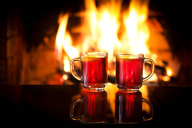 istock Hot drink mulled wine in front of warm fireplace. 587787248