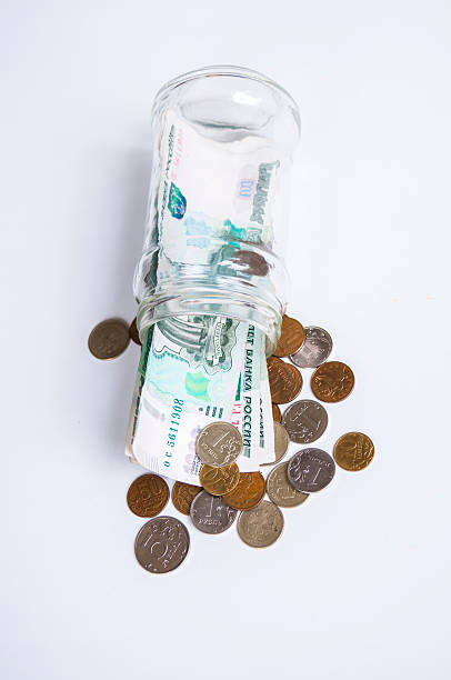 istock Glass jar with bills and coins on white background 587787524
