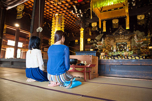 Women kneeling and praying in a buddhist temple in Kyoto