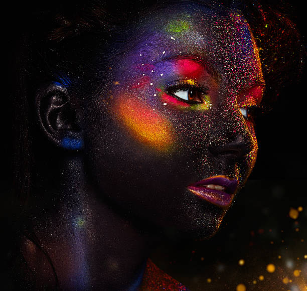 Glowing neon makeup with dramatic look. Glowing neon makeup with dramatic look in his eyes. Creative body art on the theme of space and stars. Amazing close-up portrait glow in the dark makeup. human eye nebula star space stock pictures, royalty-free photos & images