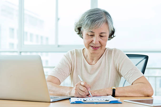 istock Senior woman using laptop at home 587795162