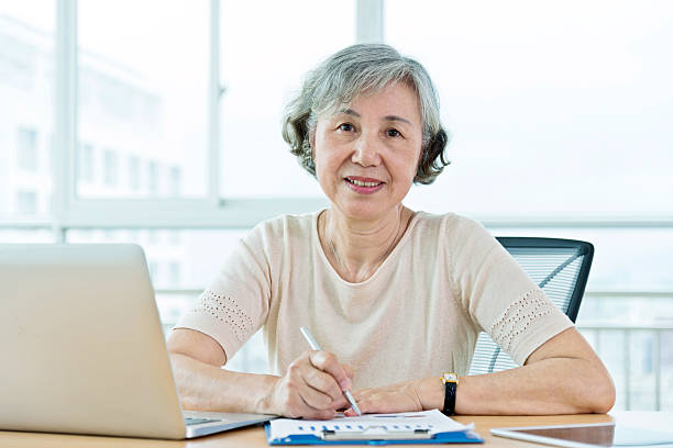 istock Senior woman using laptop at home 587795220