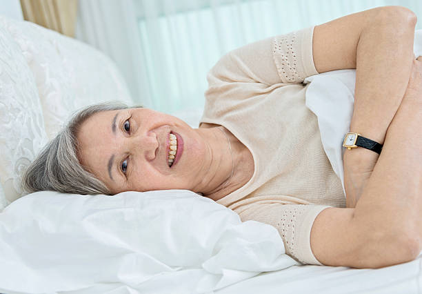 istock Senior woman lying in bed 587797190