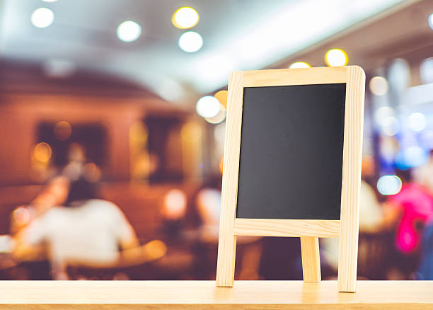 istock Blackboard with easel (menu board) on wooden table 587797282