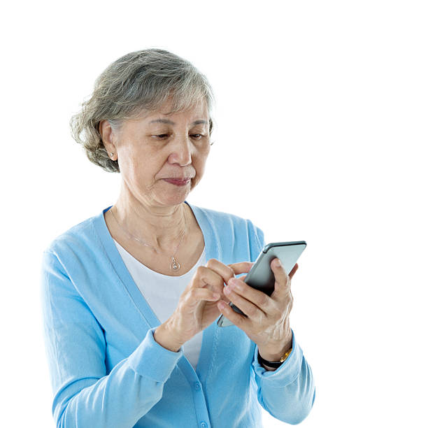 istock Senior woman text messaging on mobile phone against white backgr 587798726