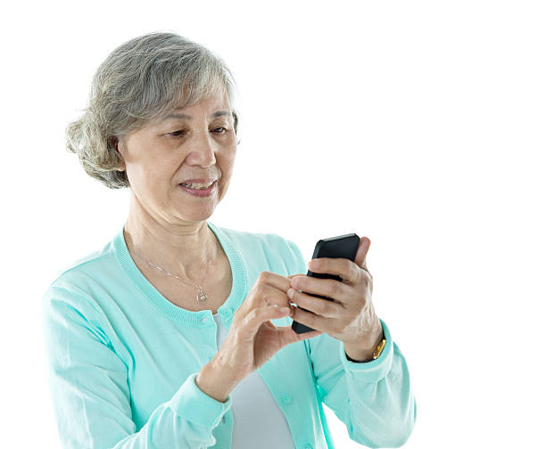 istock Senior woman text messaging on mobile phone against white backgr 587798802