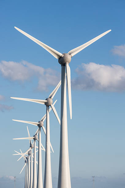 Row of wind turbines and blue sky Row of large wind turbines and blue sky flevoland photos stock pictures, royalty-free photos & images