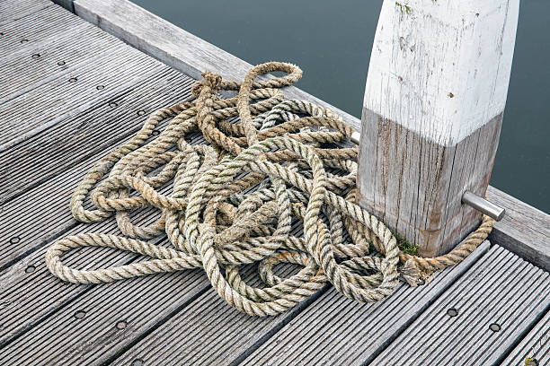 istock Wooden pier with bollard and long rope 587803728