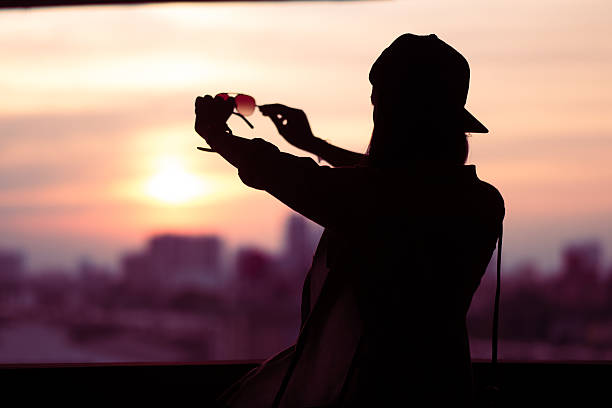 Holding eyeglassese while enjoying sunset at the beach