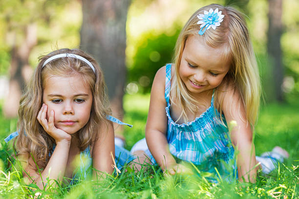 istock Two little sisters having fun in summer park 587804502