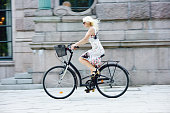 Swedish girl in summer dress on bicycle in city