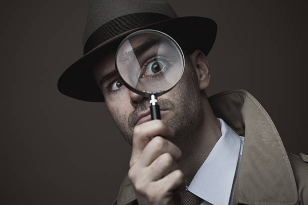 istock Vintage detective looking through a magnifier 587806594