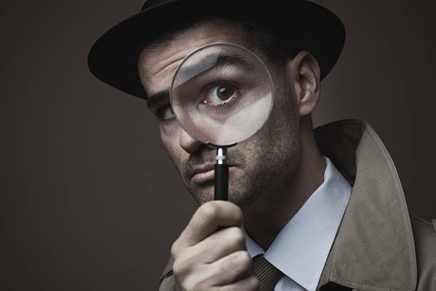 istock Vintage detective looking through a magnifier 587806854