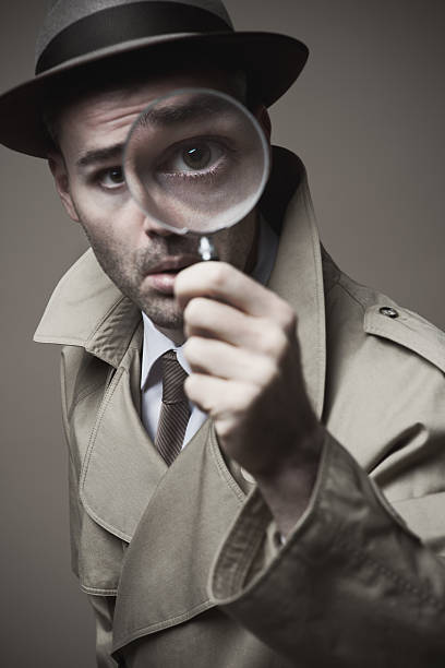 istock Vintage detective looking through a magnifier 587807146