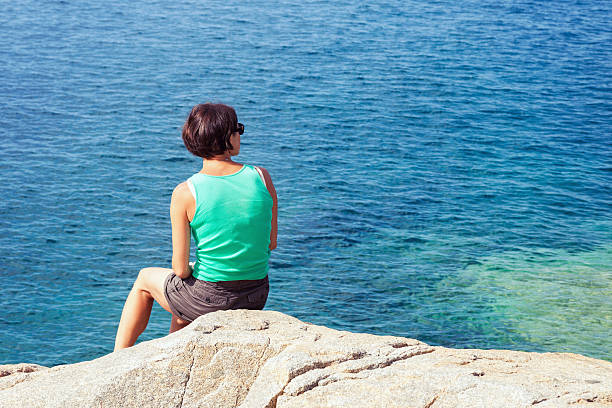 istock Young woman looking at sea 587807540