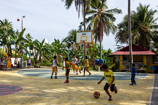 Puerto Galera, Philippines - May 17, 2012: Sabang children playing basketball in an open court in Puerto Galera, Philippines.