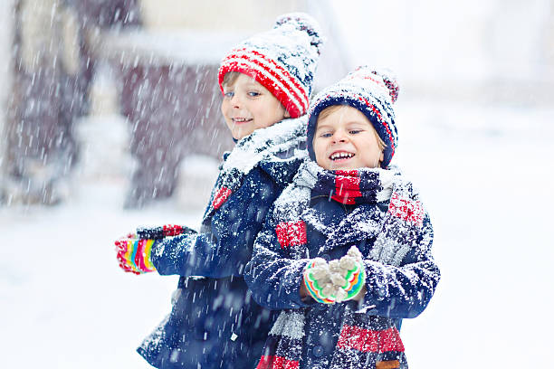 istock Happy children having fun with snow in winter 587809842