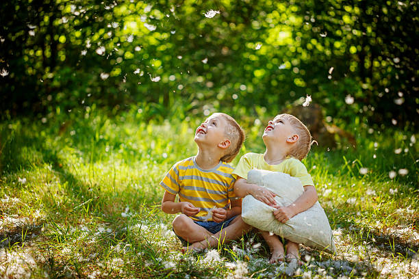 istock Kids having fun with  pillows outdoors. Two children relax in 587809856
