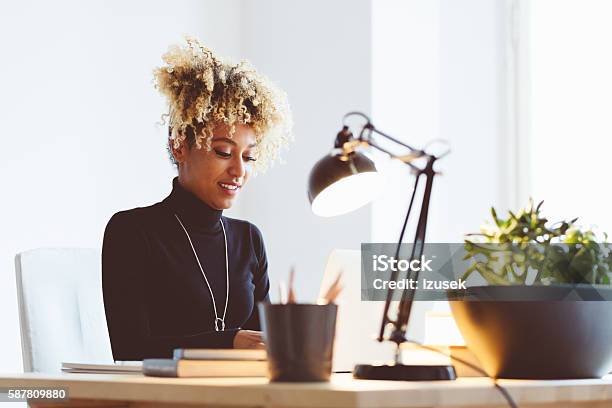 Afro American Young Woman Using A Laptop In An Office Stock Photo - Download Image Now