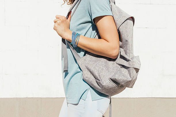 istock Slender girl with a backpack walking along the city 587810430