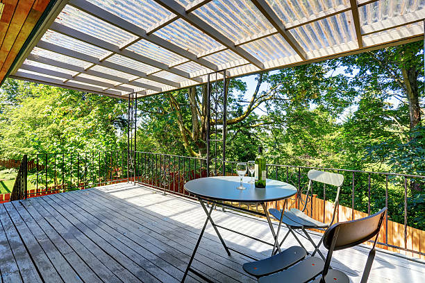 istock Covered walkout deck with metal railings and table set. 587812490