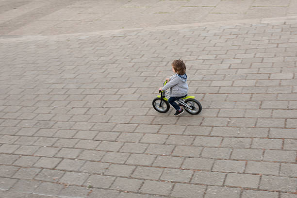 High angle vie of little boy having fun on his bicycle.