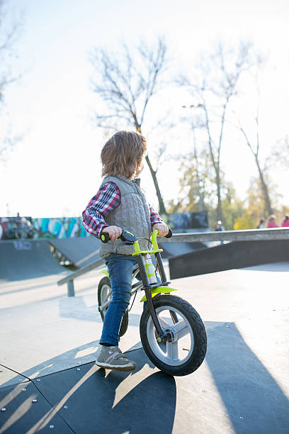 istock Little boy with a bicycle in skate park. 587812860