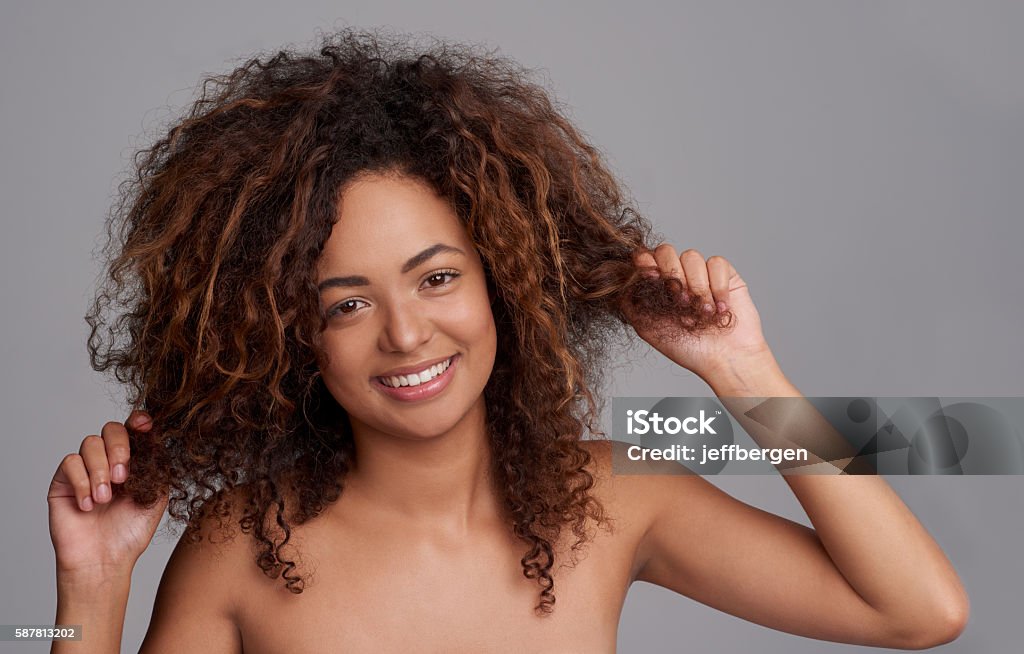 I like hair with a bit of kink in it Shot of a beautiful young woman posing over a gray background 20-29 Years Stock Photo