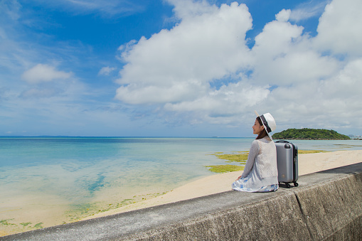 Young woman traveling with the sea in Okinawa