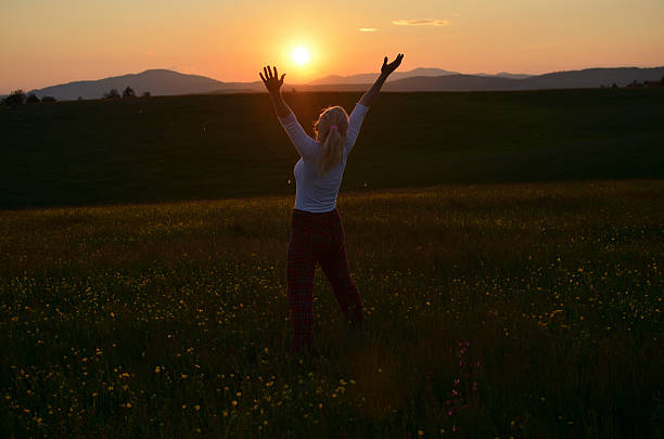 istock Joyful Woman Spreading Her Arms in Sunset 587816488