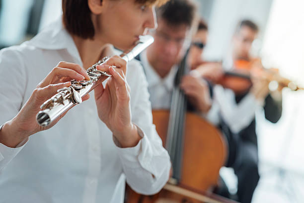 istock Flutist playing her instrument on stage 587817144
