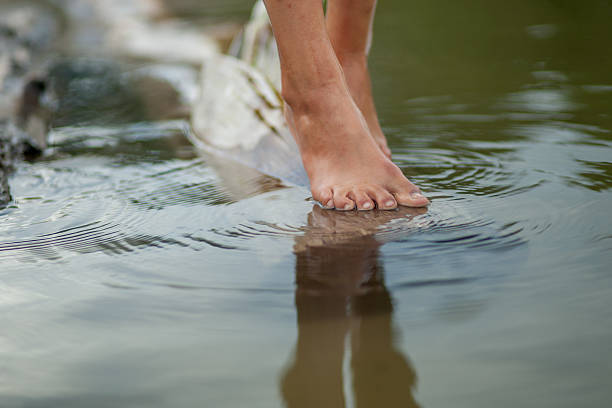 istock Girls legs on the water 587818162